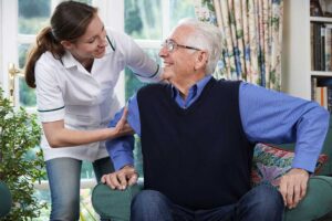 Older adults play cards and complete a puzzle together at a bright assisted living activity table.